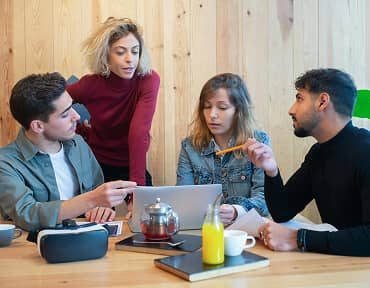 Business group coordinating information around a laptop